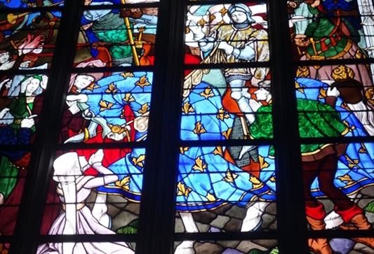 Photo of a stained glass by Jacques Galland and Esprit Gibelin depicting Joan of Arc live to illustrate  the Orléans Joan of Arc Walking Tour in the Loire Valley, France.