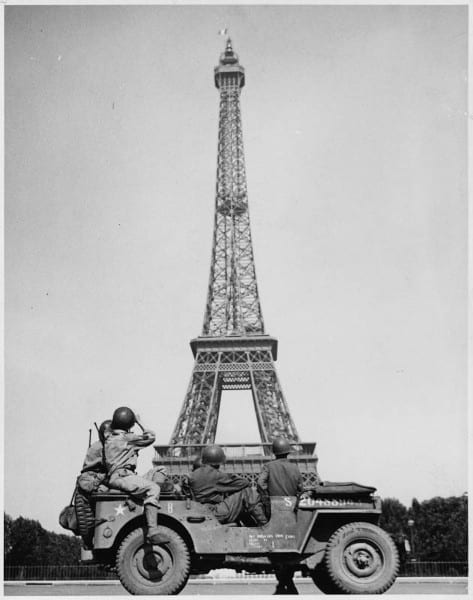 Liberating American Troops sitting in a Willy’s Jeep in front of the Eiffel Tower  to illustrate World War II Paris guided tour