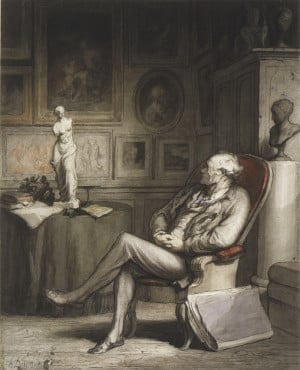 A man sitting in a chair in front of a small reproduction of Venus de Milo.