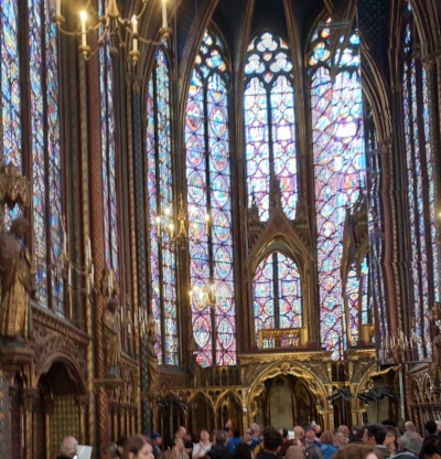 Sainte-Chapelle interior showing floor-to-ceiling 13th century stained glass windows in vibrant reds and blues with Gothic architecture