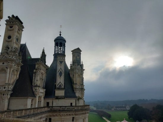 Amazing photo of the winter sun percing the clouds in the terrace of Chambord Castle.