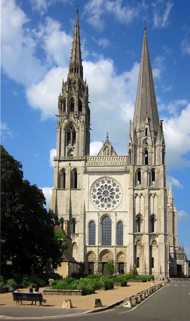West façade of Chartres Cathedral showing the Portail Royal and the two asymmetrical towers — the plain Romanesque south tower completed c.1160 and the ornate Flamboyant Gothic north spire completed by Jean Texier in 1513