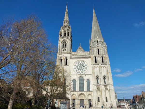 West façade of Chartres Cathedral showing the Portail Royal and the two asymmetrical towers — the plain Romanesque south tower completed c.1160 and the ornate Flamboyant Gothic north spire completed by Jean Texier in 1513